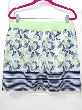Tee Time golf skort features a vibrant green and navy blue leaf pattern